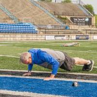 Scott Grissom doing pushes on the football field in Lubbers Stadium